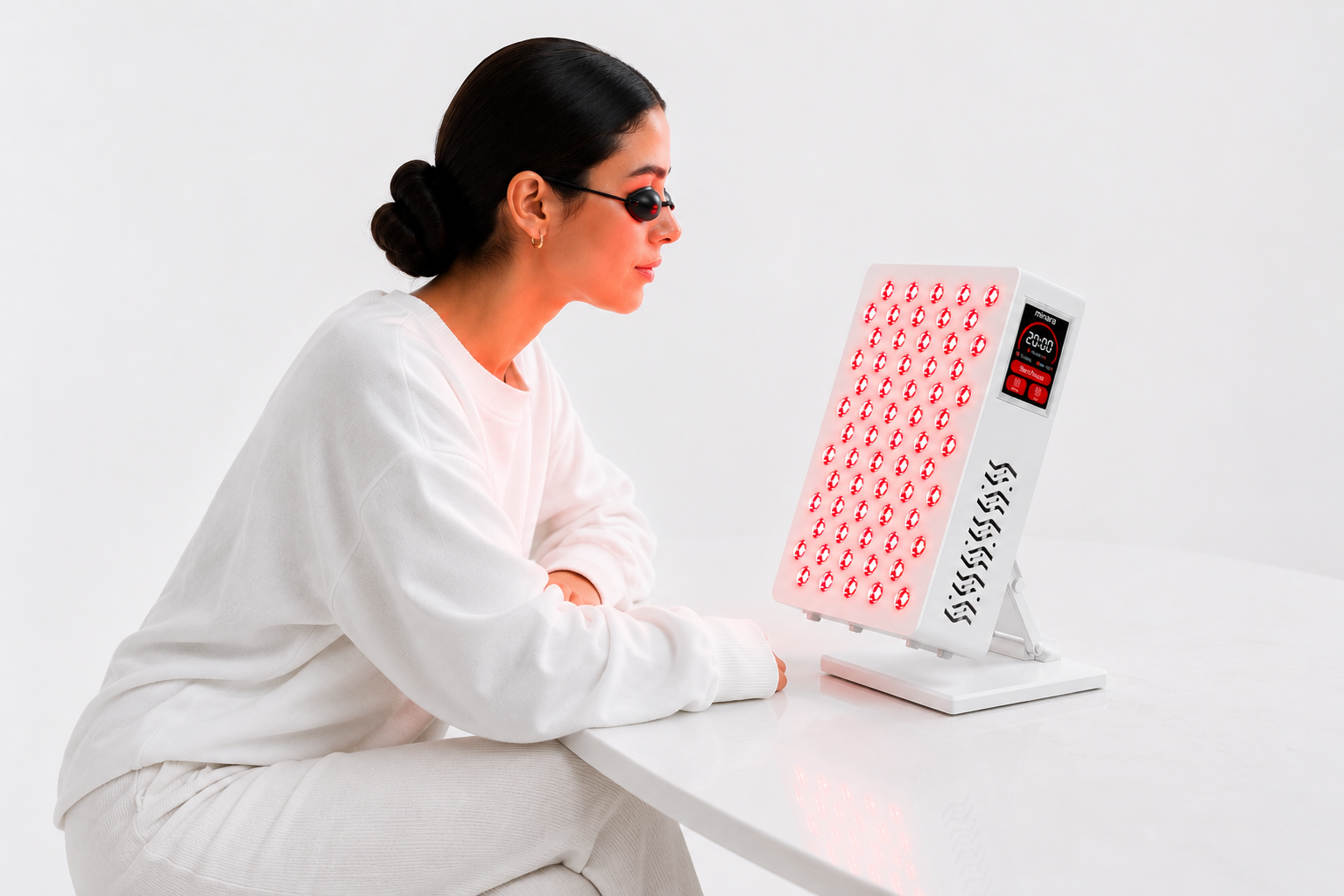 A woman using the minara panel for a facial session